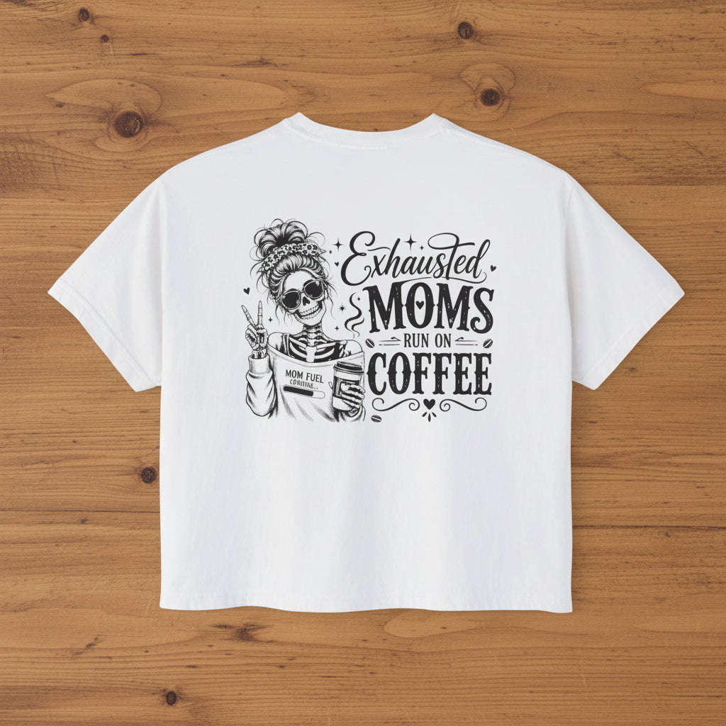 White women’s boxy cropped tee with black Exhausted Moms Run On Coffee graphic on the back.