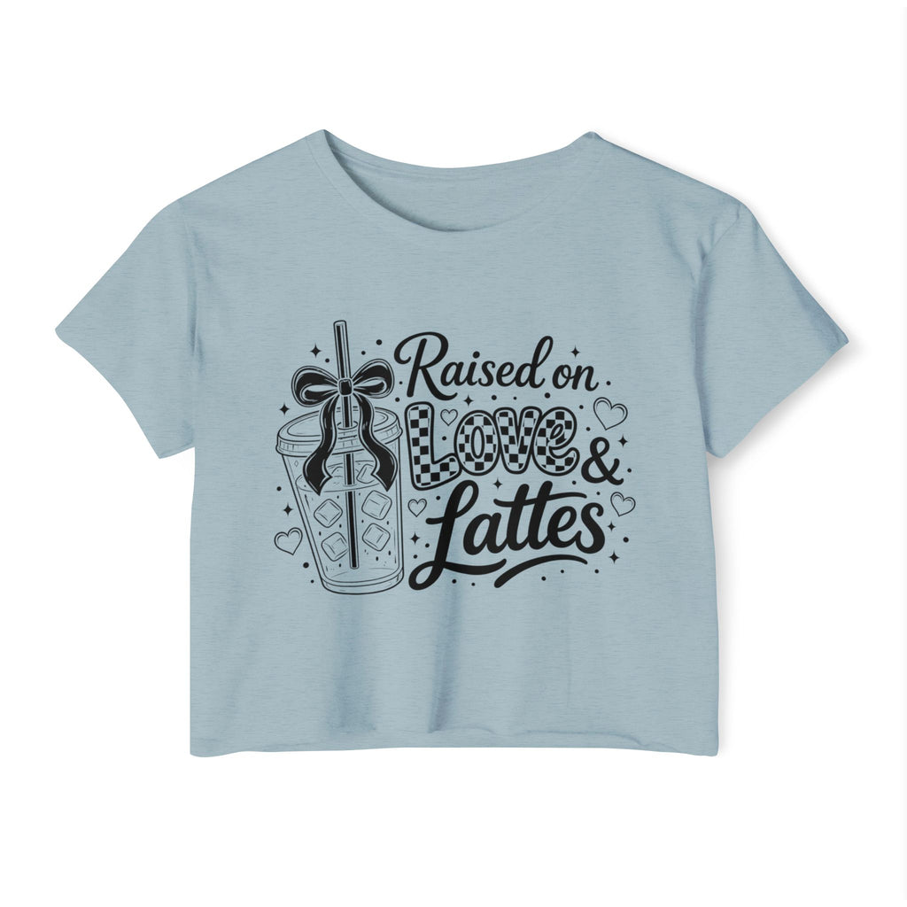 Powder blue cropped women’s T-shirt shown in a clear front-facing product photo with a bold black “Raised on Love & Lattes” design featuring a bow, checkerboard accents and café beverage. This pastel coffee lover shirt is ideal for spring outfits, relaxed weekends and morning drink runs. Unique gift choice for baristas, cold brew enthusiasts, college students and latte-loving friends.