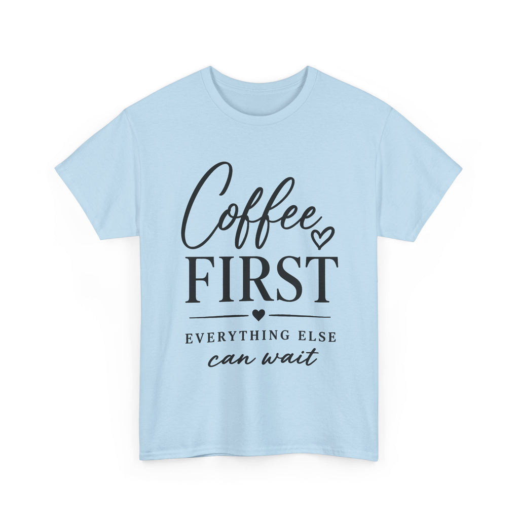 A light blue short-sleeve crewneck t-shirt with a black graphic print on the front reading 'Coffee FIRST EVERYTHING ELSE can wait' with small heart accents, shown on a plain white background.