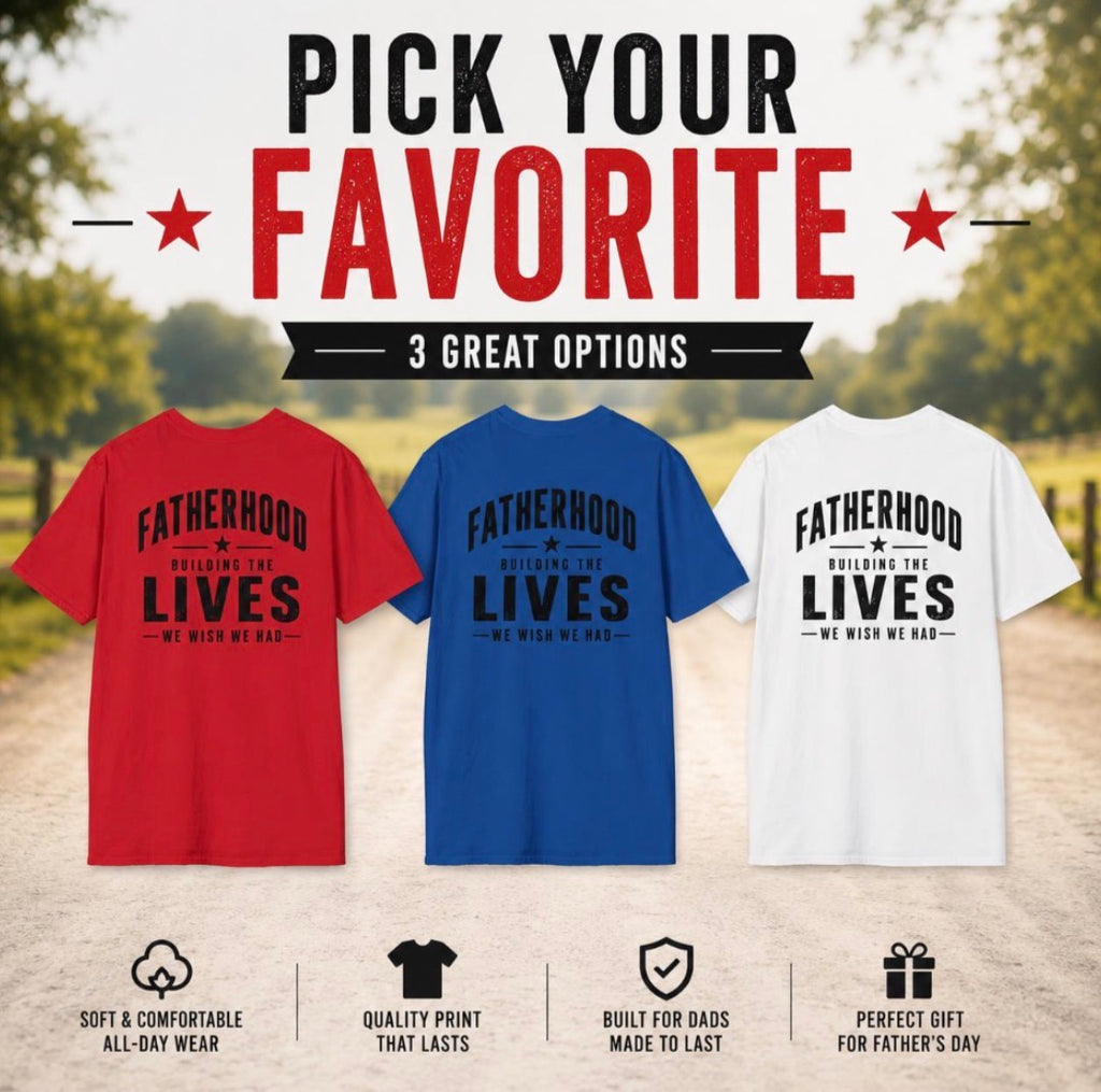 Fatherhood graphic T-shirt color lineup in red, royal blue, and white, displayed outdoors with Building the Lives We Wish We Had back print.