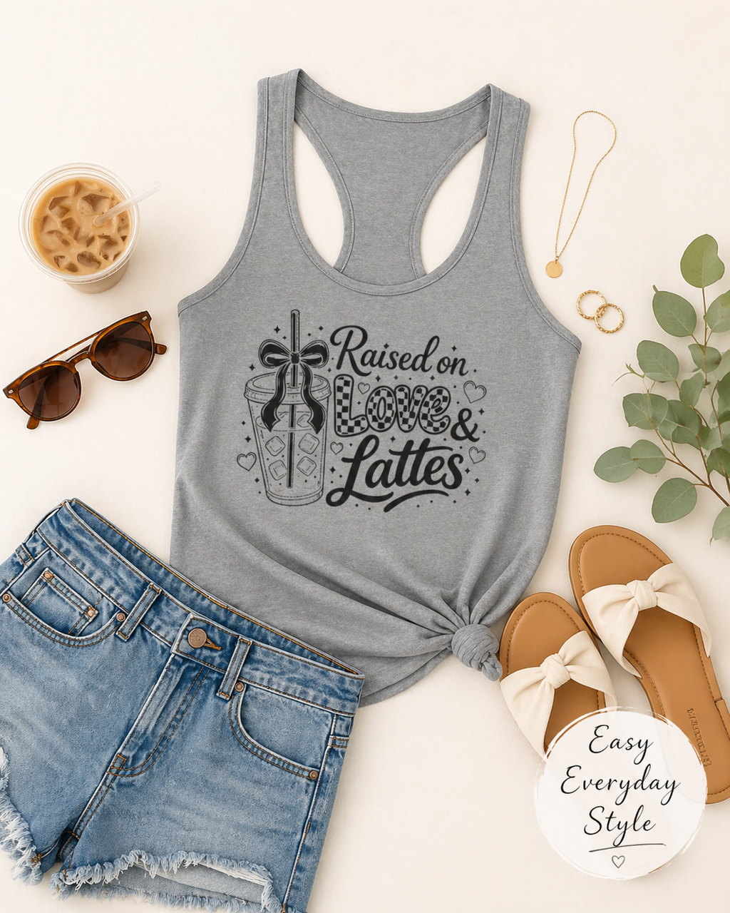Heather grey women's coffee mom crop top outfit flat lay with denim shorts, sandals, sunglasses, coffee cup, and Raised on Love and Lattes front print.