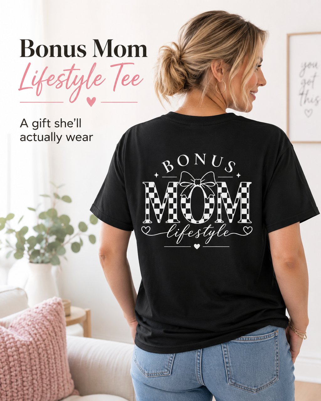 Woman wearing a black t-shirt with 'Bonus Mom Lifestyle' text in a home setting