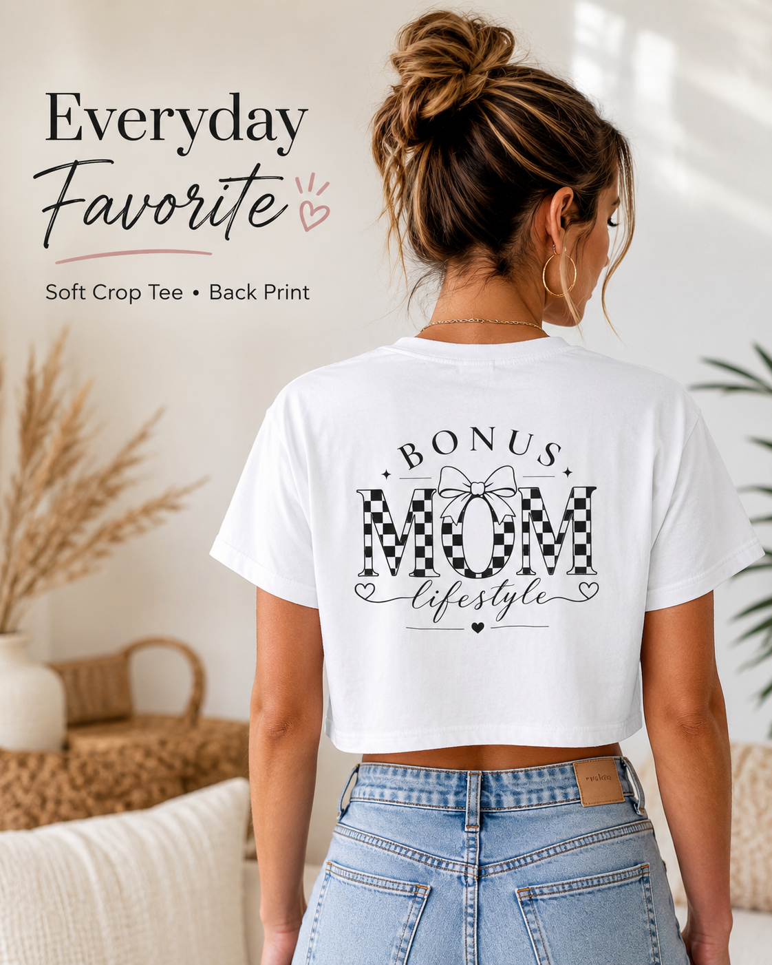 Person wearing a white t-shirt with 'Bonus Mom Lifestyle' print, standing in a home setting.