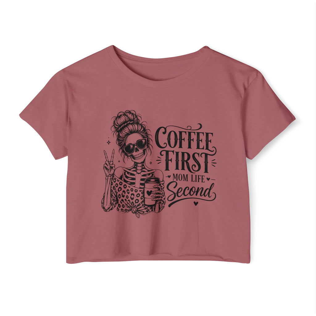 Pink t-shirt with a graphic of a woman and text 'Coffee First, Mom Life Second' on a white background