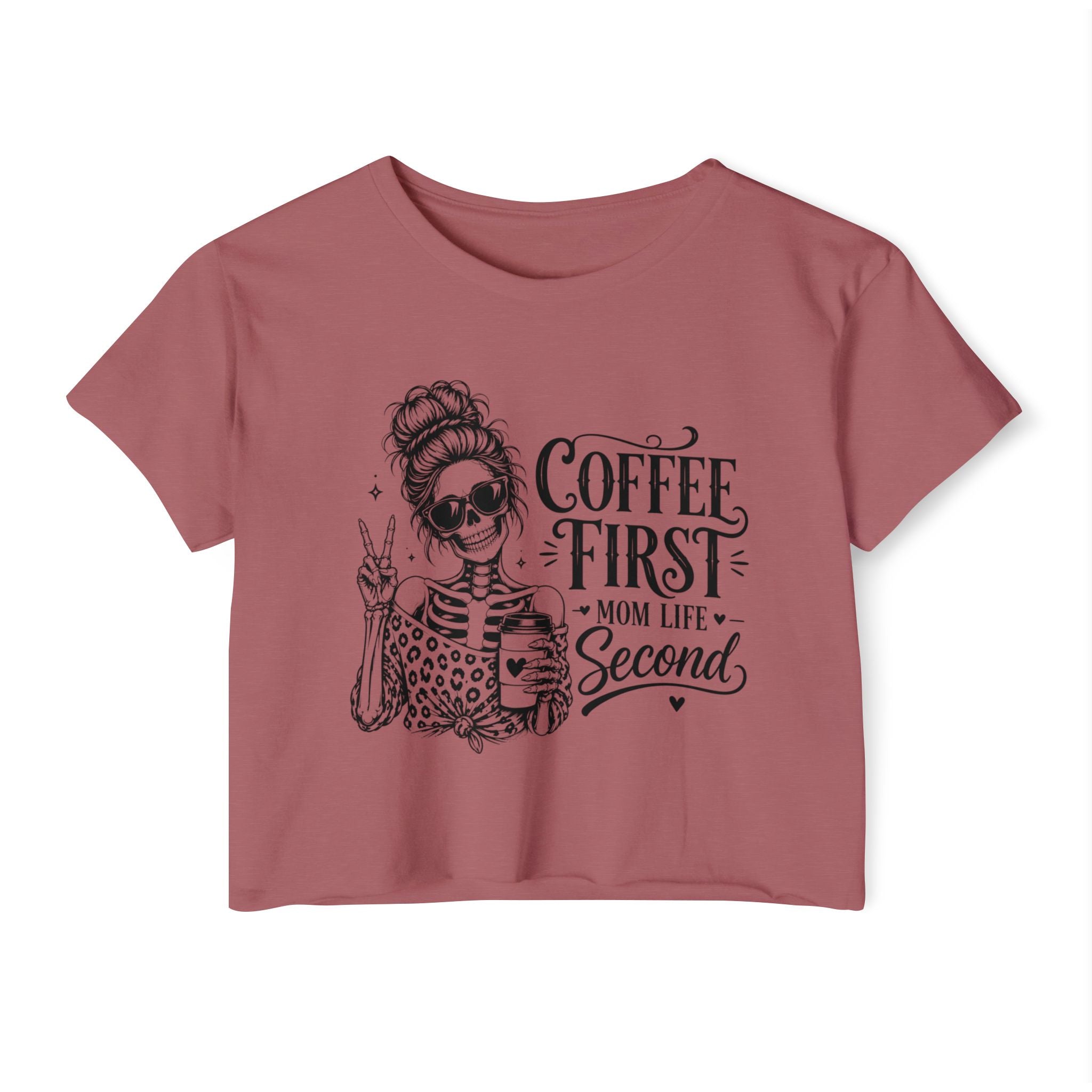 Pink t-shirt with a graphic of a woman and text 'Coffee First, Mom Life Second' on a white background