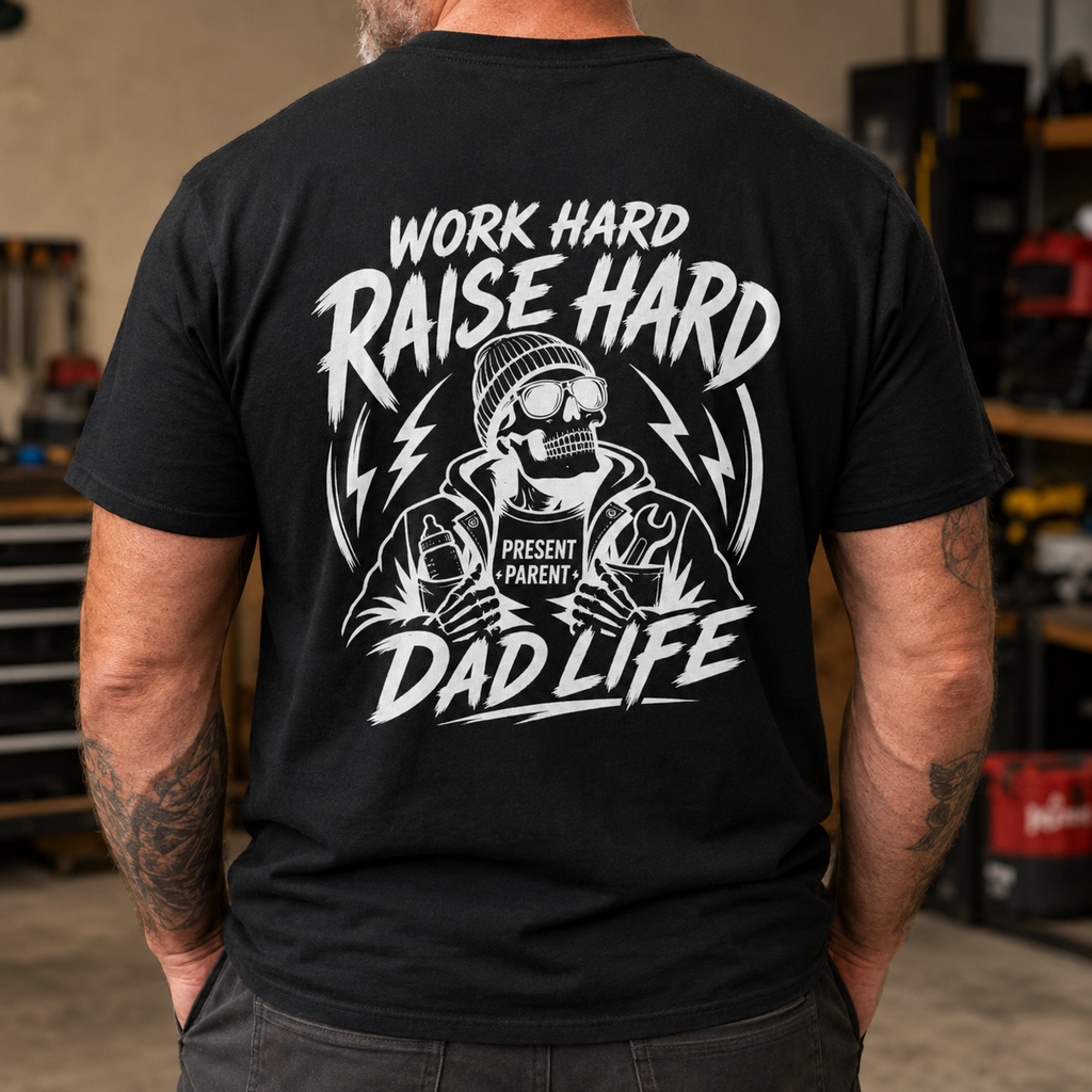 Black men’s graphic T-shirt modeled from the back inside a rugged workshop, featuring a bold white skeleton design with the words “Work Hard Raise Hard Dad Life” and PresentParent detail. Blue collar dad shirt, working father apparel, construction dad gift, masculine skull tee, Father’s Day present and TikTok Shop workwear for hardworking dads.