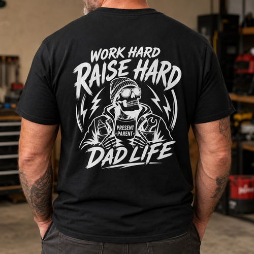 Black men’s graphic T-shirt modeled from the back inside a rugged workshop, featuring a bold white skeleton design with the words “Work Hard Raise Hard Dad Life” and PresentParent detail. Blue collar dad shirt, working father apparel, construction dad gift, masculine skull tee, Father’s Day present and TikTok Shop workwear for hardworking dads.