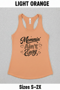 Flat lay of a light orange Mommin’ Ain’t Easy racerback tank top with black coffee mom design, cute Mother’s Day gift shirt for busy moms.