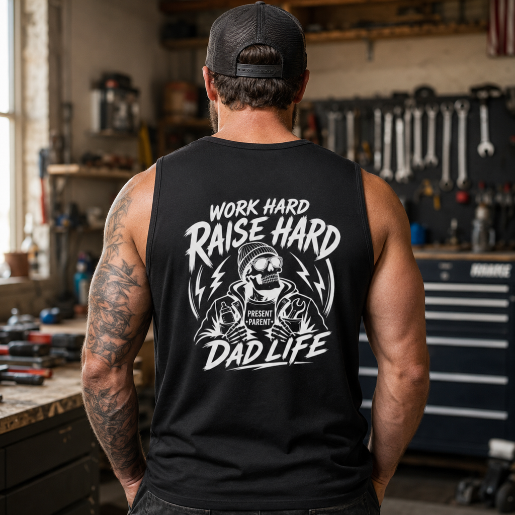 Garage lifestyle photo of a man wearing a black dad tank with a large back print, made for hardworking fathers, mechanics, builders, shop workers, tattoo dads, husband gifts, Father’s Day presents, and everyday sleeveless workwear.